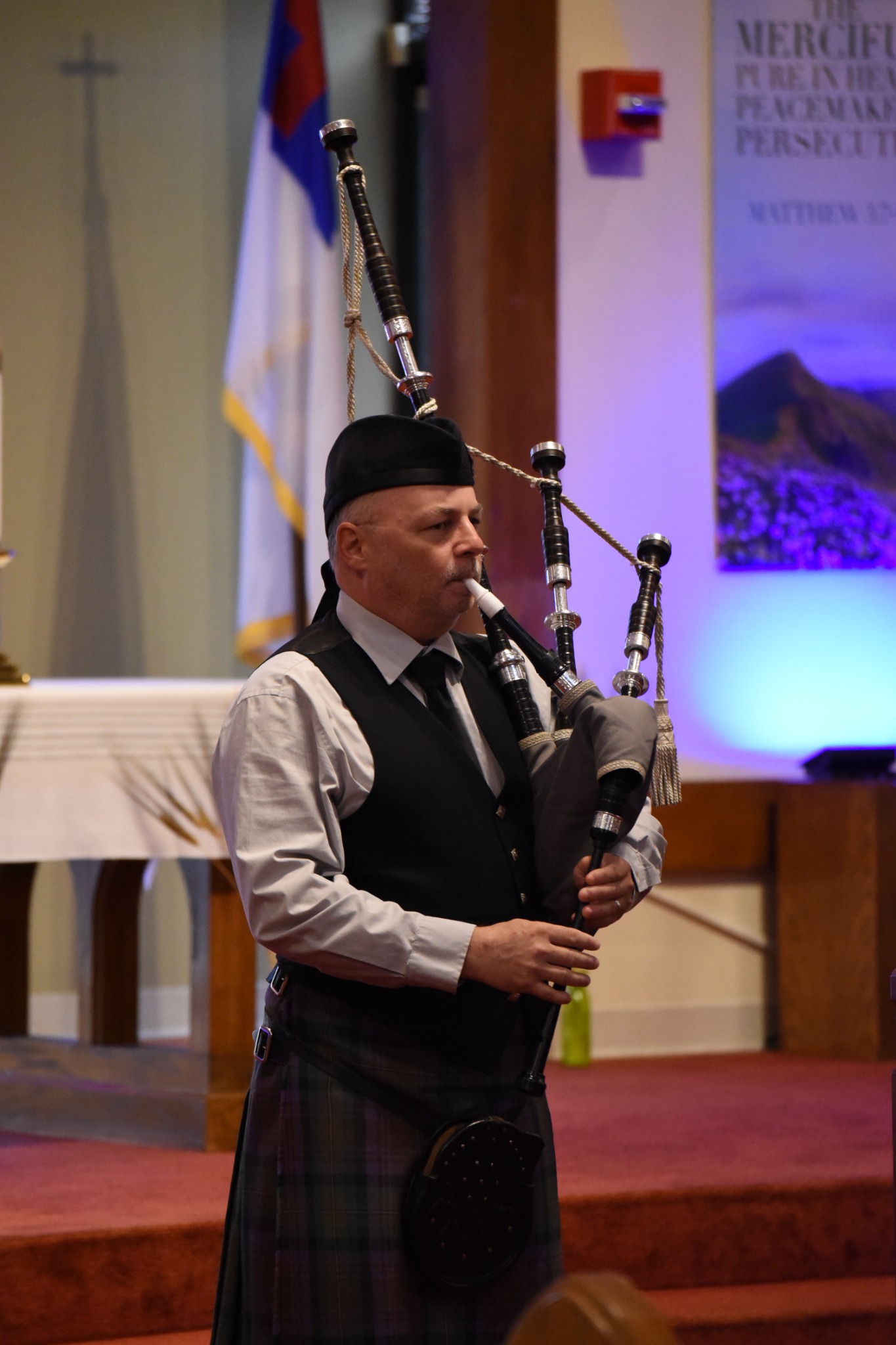 Richard Kean playing bagpipes at a church wedding